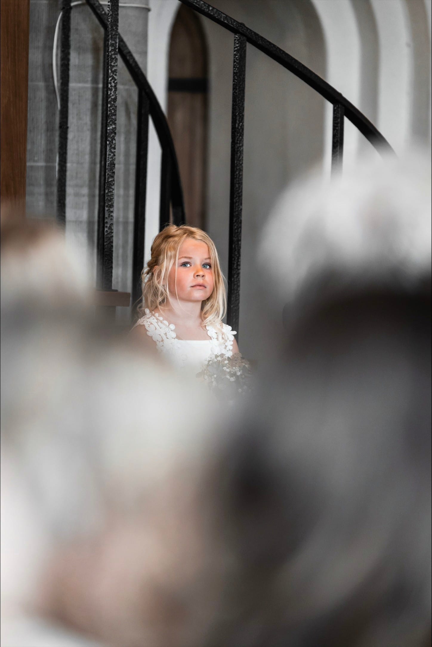 Blomsterflicka med allvarlig blick i kyrkan under ceremonin